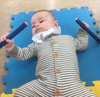 baby holding sticks Small